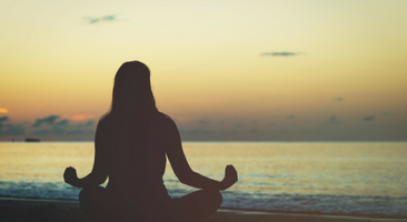 woman medicating on beach