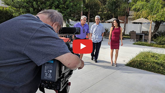 man behind camera framing up three people walking