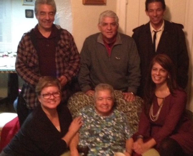 older woman in chair surrounded by people