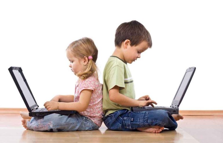 two small children pretending to type on laptops