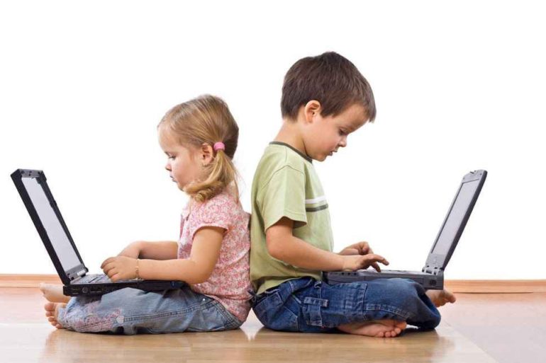 two small children pretending to type on laptops