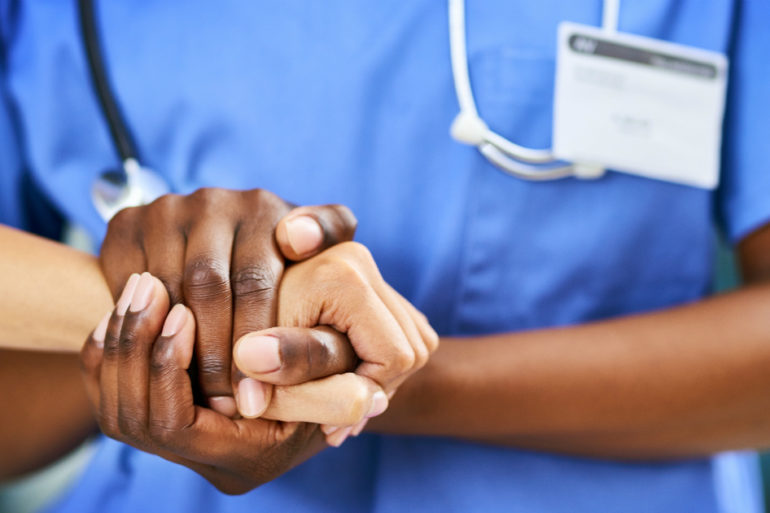 Nurse and patient holding hands