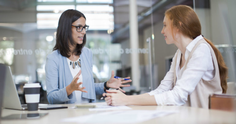 two women talking in office