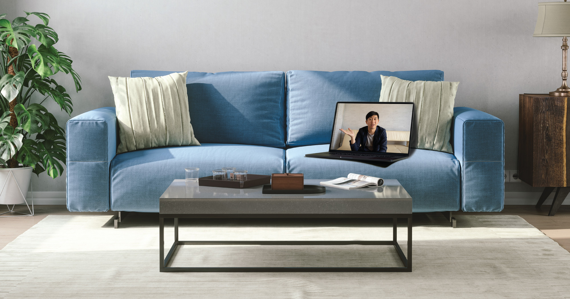 Couch and coffee table with laptop on couch displaying image of a person