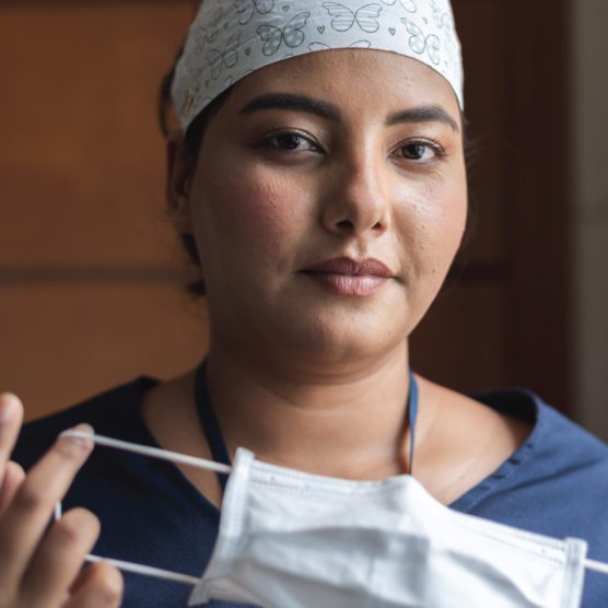 Nurse putting on surgical mask