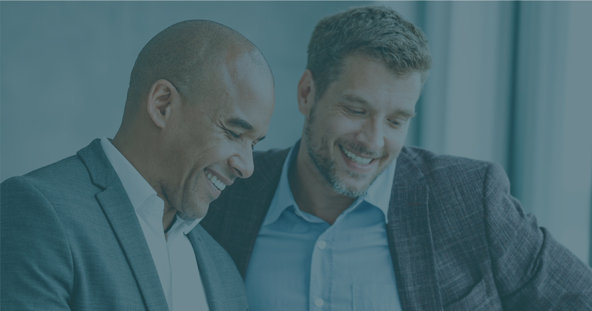 Photo of two business men talking and smiling.