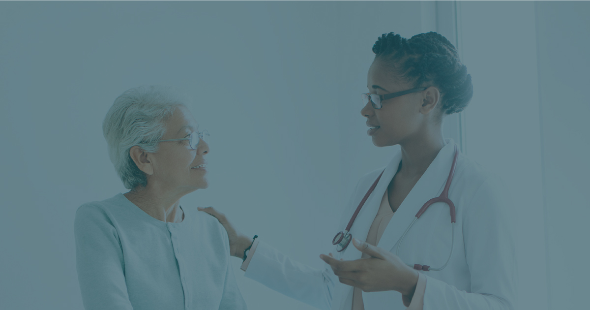 Photograph of a female doctor helping a patient.