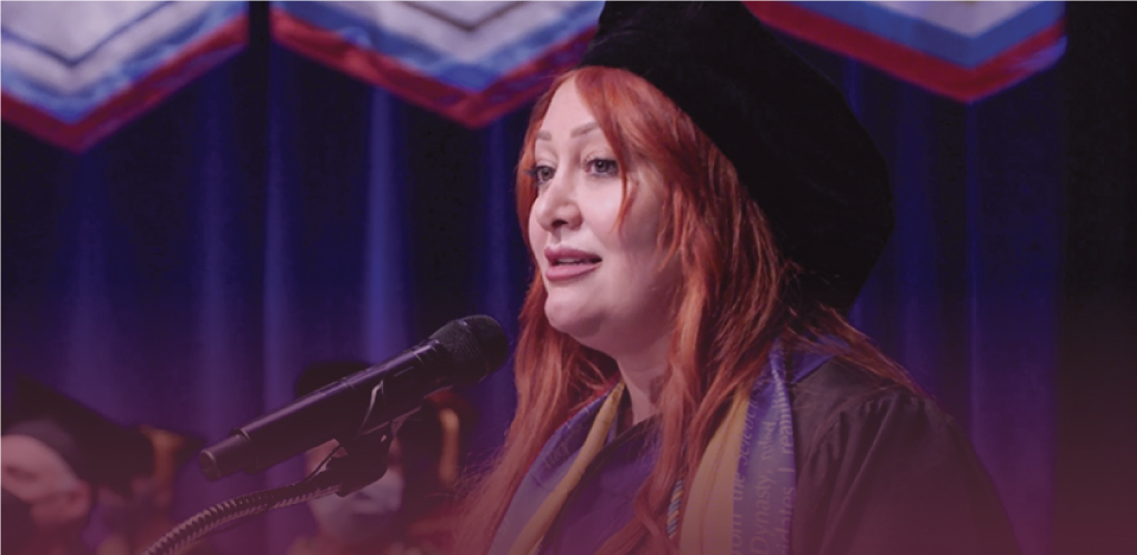 Photo of The Chicago School graduate Lucina Babayants giving a speech at commencement.