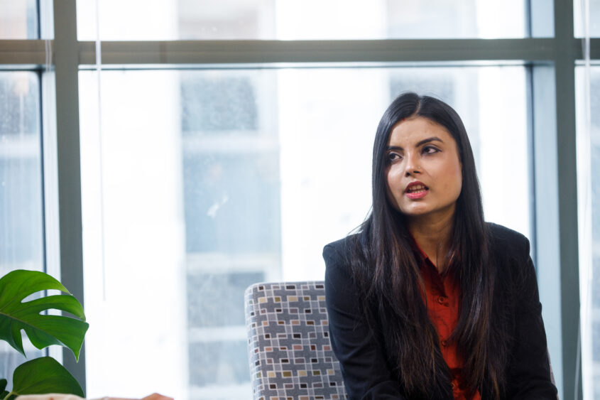 TCS student Pooja Das in chair by window