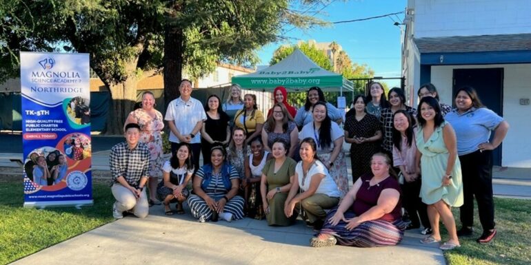 Volunteers from The Chicago School's Community Partnerships community pose for a group photography outside.