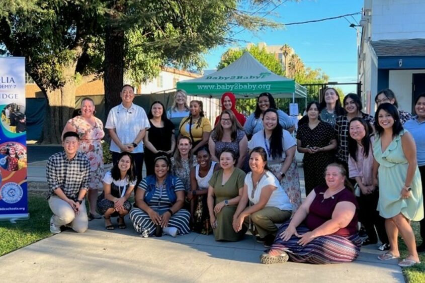Volunteers from The Chicago School's Community Partnerships community pose for a group photography outside.