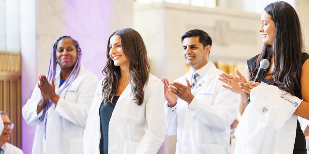 IllinoisCOM students receive their white coats at the school's inaugural white-coat ceremony.