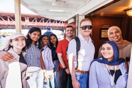 Six young women and two young men posed on a boat.
