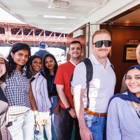 Six young women and two young men posed on a boat.
