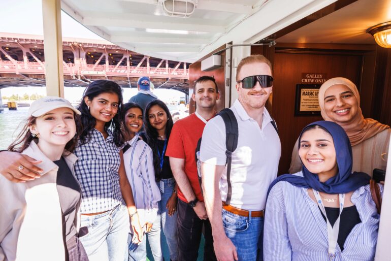 Six young women and two young men posed on a boat.