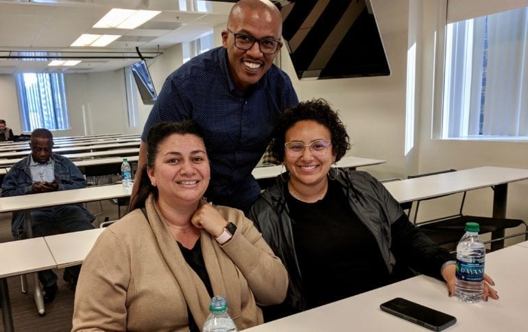 three people smiling at the camera