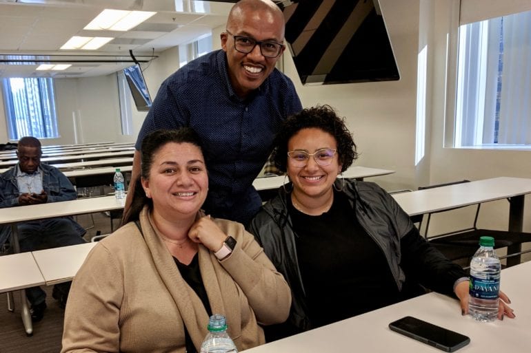 three people smiling at the camera