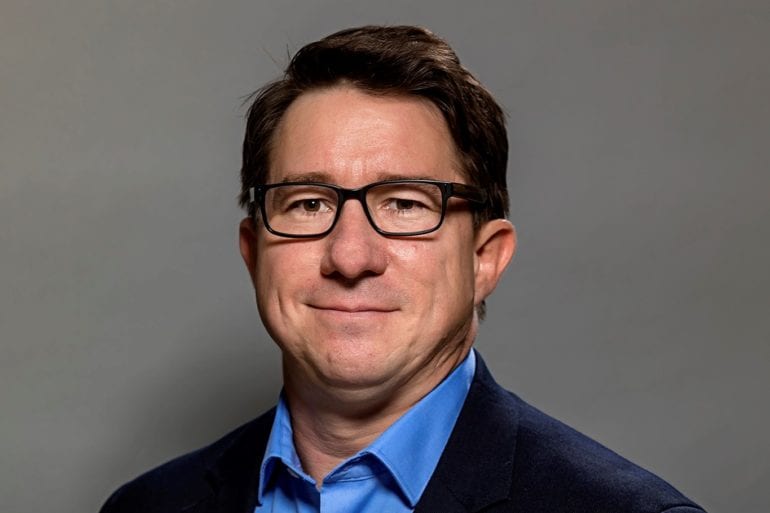 man with glasses and dark blue suit
