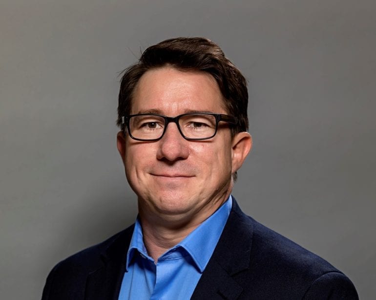 man with glasses and dark blue suit