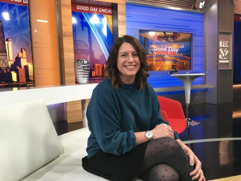 woman in green sweater sitting on couch in news studio
