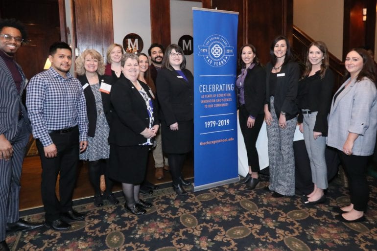group of people standing near 40 year celebration banner