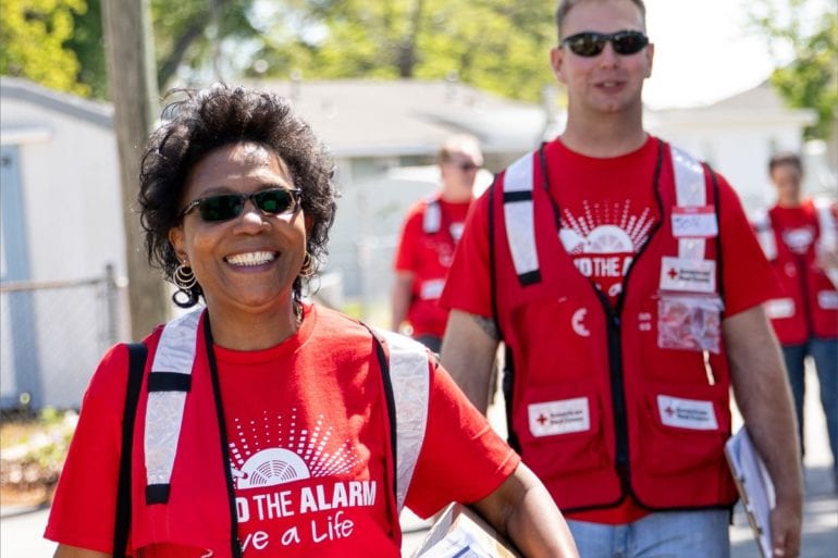 people in red shirts doing a blood drive