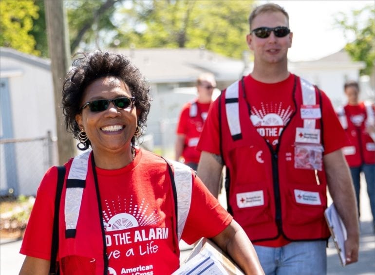 people in red shirts doing a blood drive