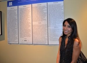 woman standing and smiling next to large printout on the wall