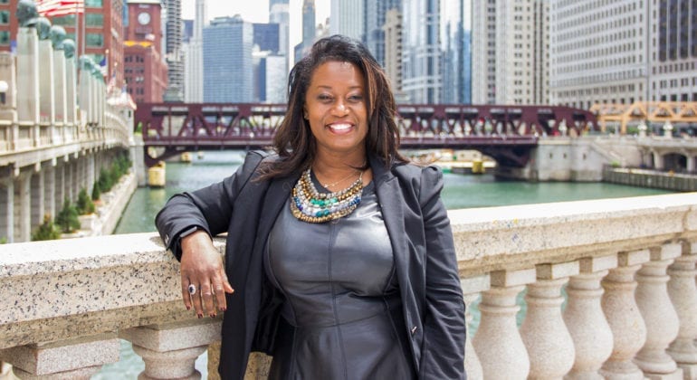 woman in dark clothes standing on stone bridge in Chicago