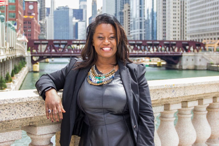 woman in dark clothes standing on stone bridge in Chicago
