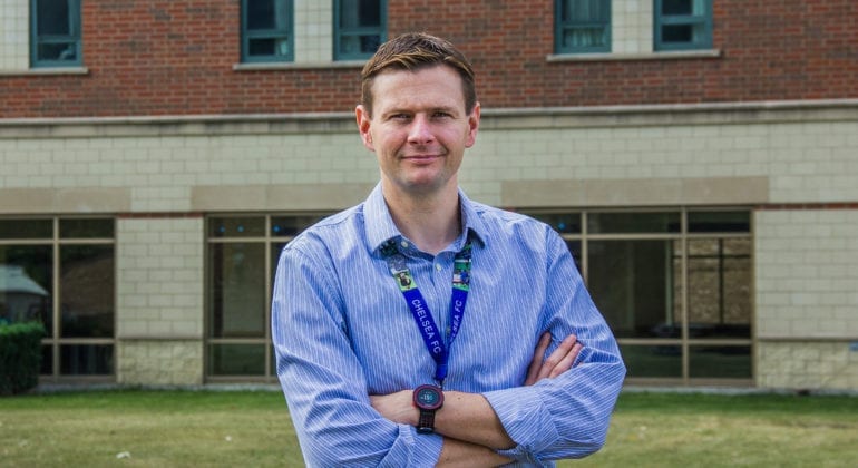 man in blue striped shirt with arms crossed