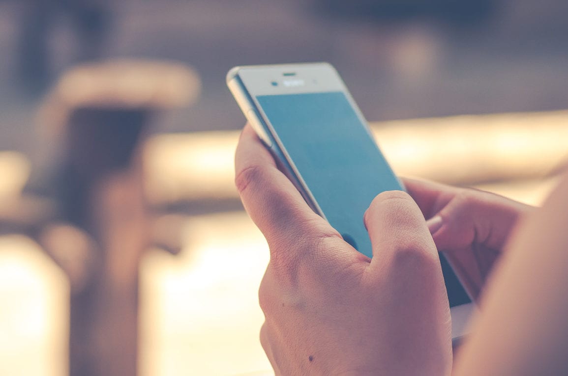 person typing on smart phone