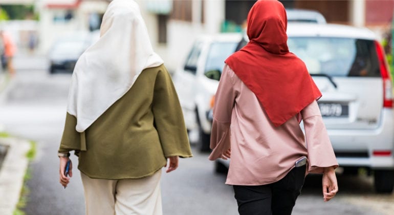 two women walking with head scarves