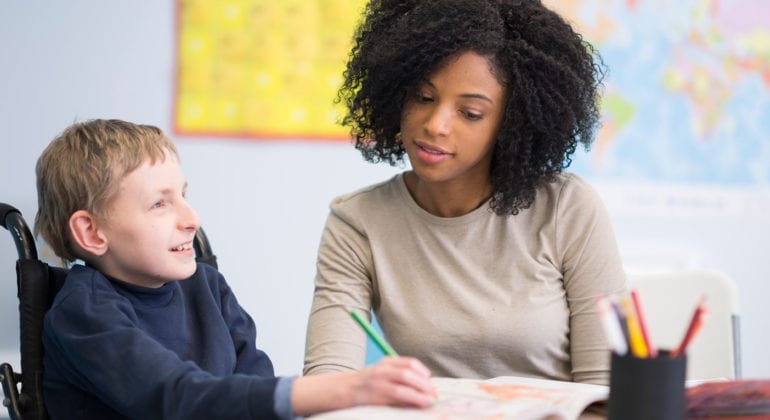 woman helping child with special needs