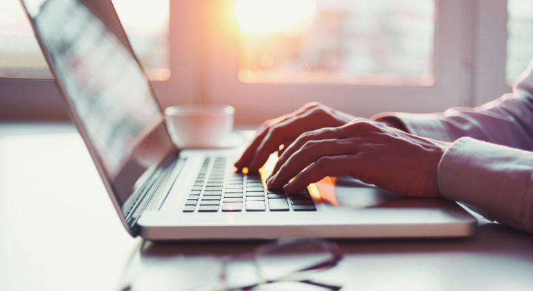 hands typing on a laptop