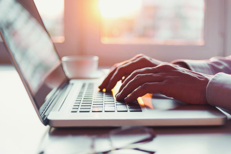 hands typing on a laptop