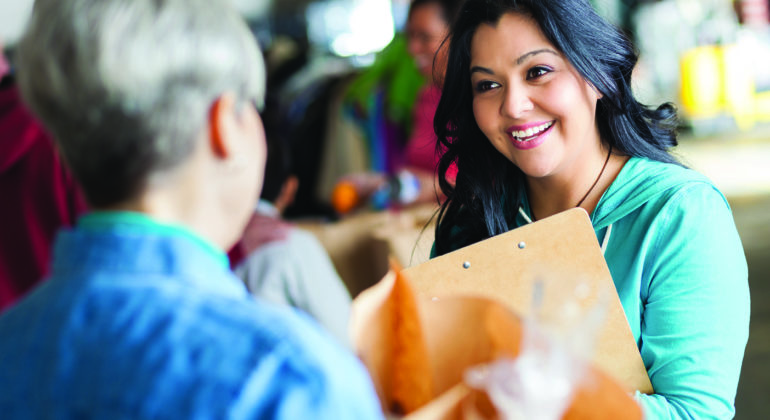 woman in blue shirt holding clipboard