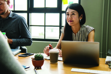 woman behind a laptop with a coffee