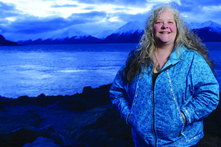 woman standing near lake with mountains