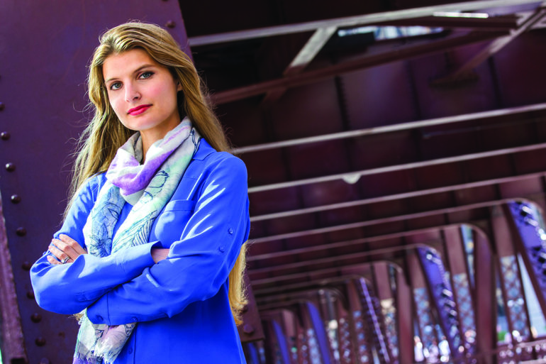 woman in blue shirt standing with arms crossed