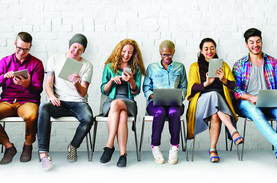 people sitting on chair looking at phones and tablets