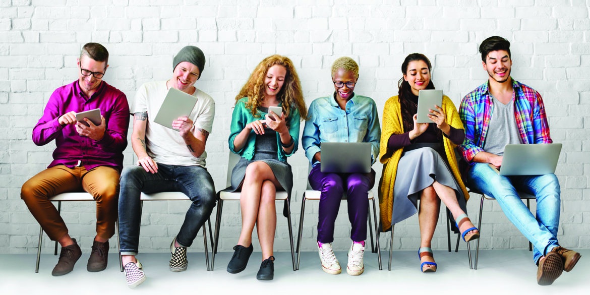 people sitting on chair looking at phones and tablets