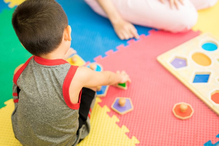 child playing with shape toys