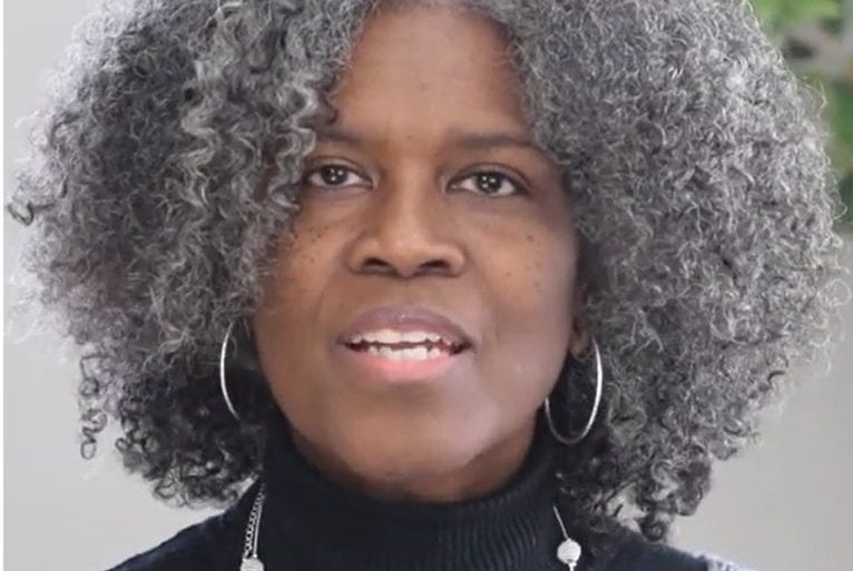 older woman in black and gray outfit