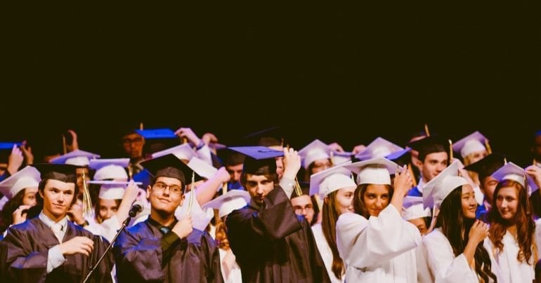 students turning their graduation tassles