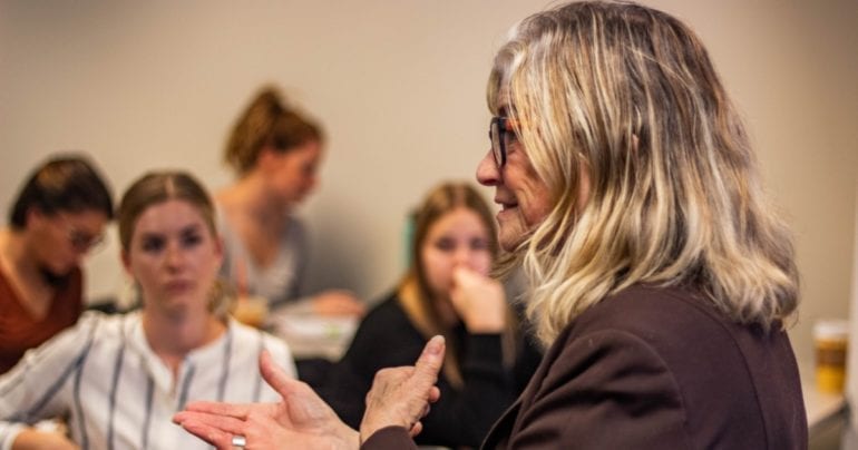 woman talking in front of group of young women