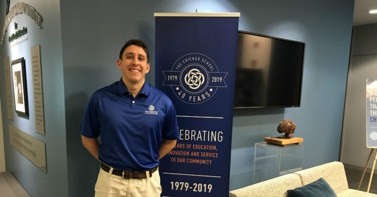 man in blue shirt next to blue banner
