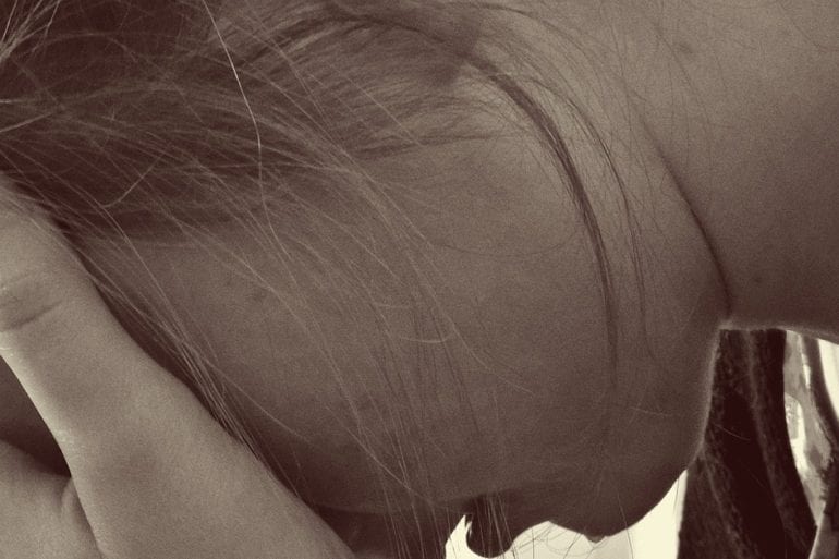 woman with hands covering face