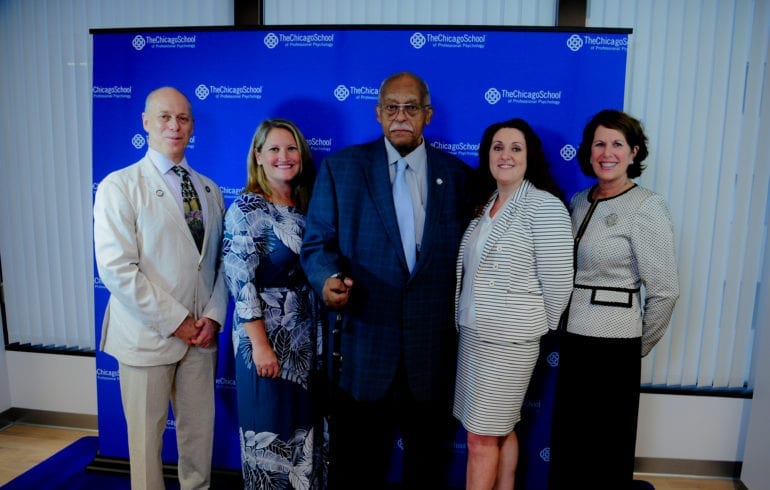 five people standing in front of blue background