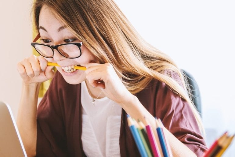 woman biting down on pencil